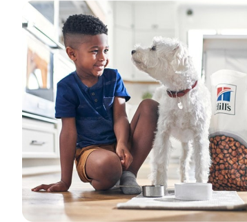 Un jeune garçon et un chien dans la cuisine